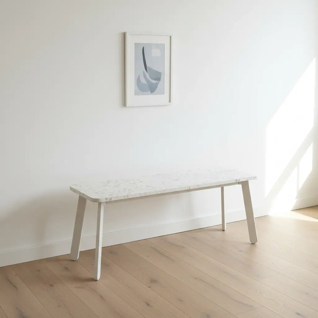 White HDPE polymer bench with a speckled panel top in a bright, minimalist interior with a framed print above
