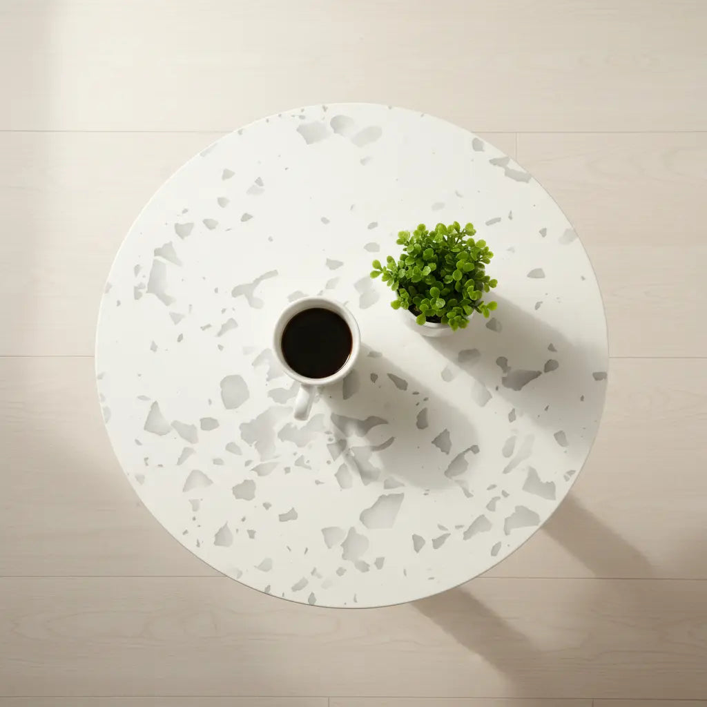 Top view of a white recycled plastic side table with gray speckled panel pattern, holding a coffee mug and small green plant